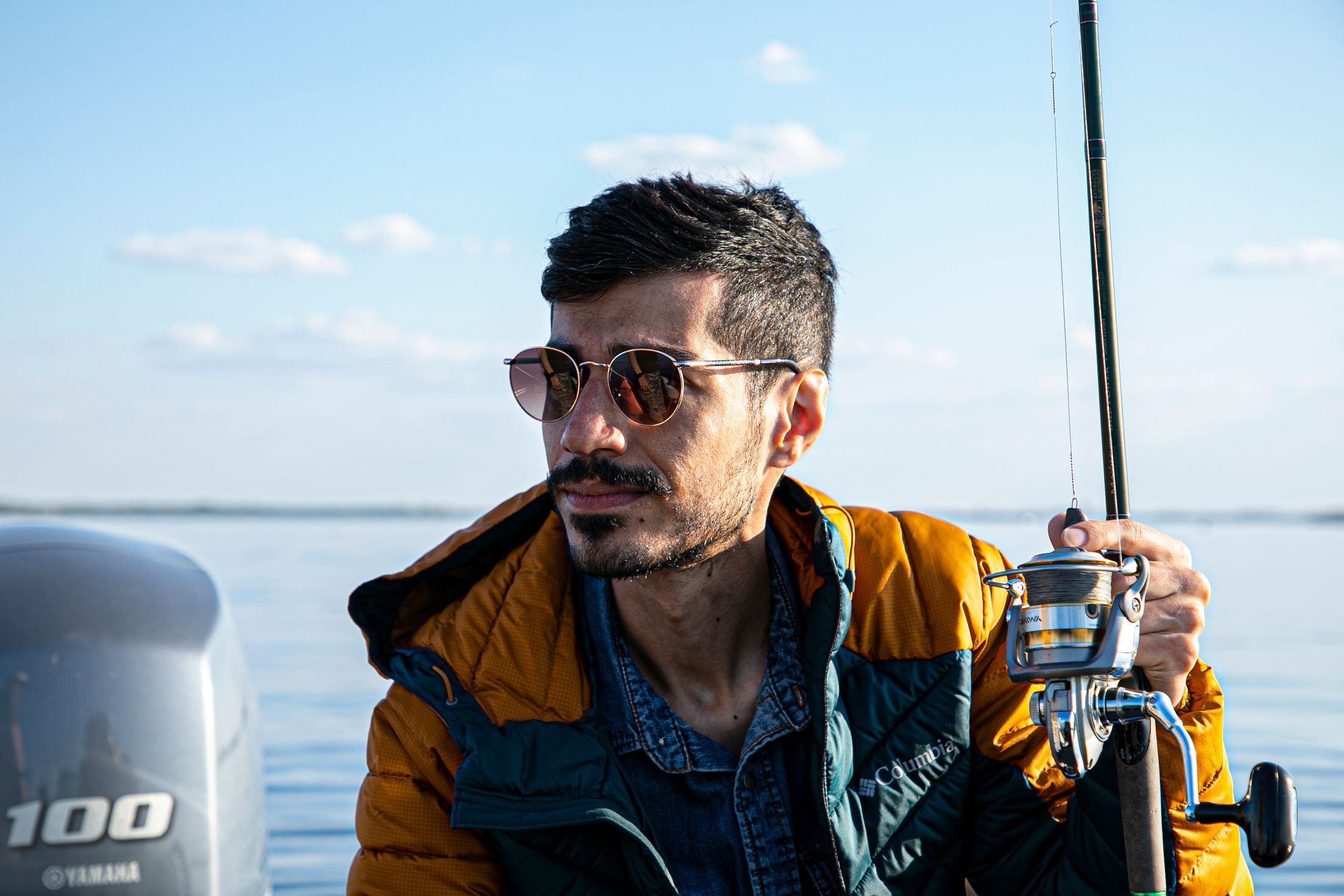 Angler wearing sunglasses while fishing from a boat